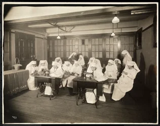 Frauen in weißen Kitteln, in einem Nähkurs, vermutlich während oder im Zusammenhang mit dem Ersten Weltkrieg, New York, ca. 1920